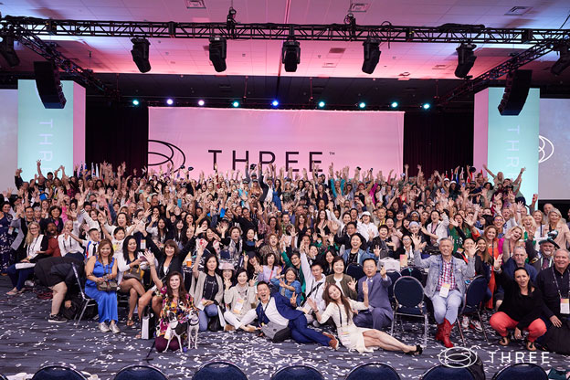 a large group photo of attendees at the power of three convention in anaheim